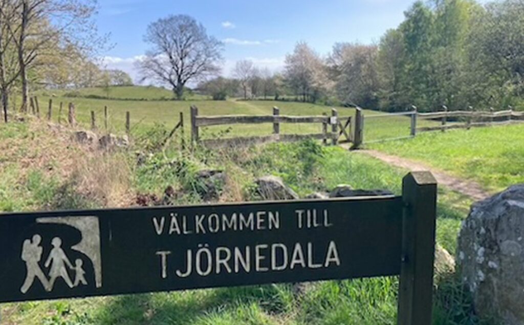 Foto från Tjörnedala med hage och lövträd .